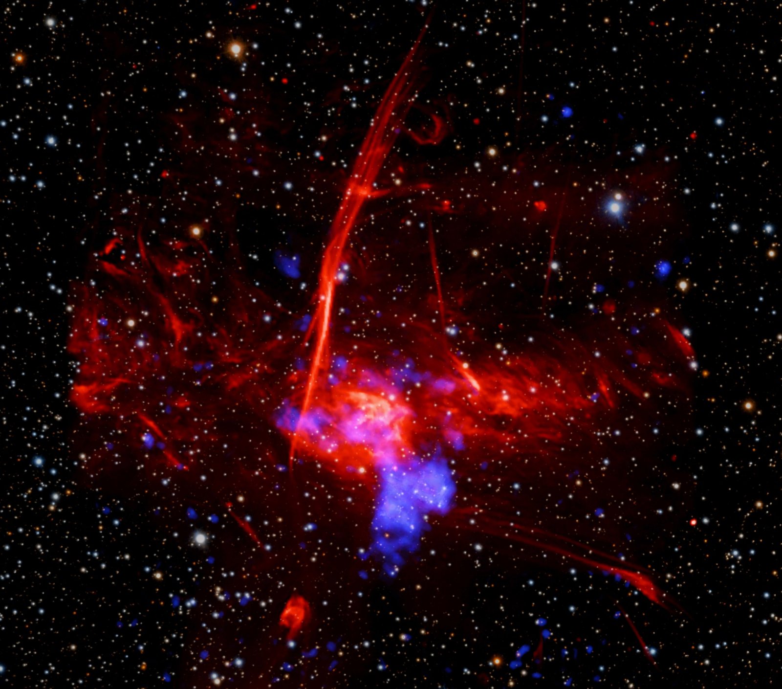 Astronomers may have uncovered a new supernova remnant in a star-forming region near the center of the Milky Way galaxy using data from Chandra and XMM-Newton. If confirmed, this would be one of the closest supernova remnants to the supermassive black hole in the Galactic Center. This image shows the region where the evidence was found, which contains X-rays from Chandra and XMM-Newton, radio data from the MeerKAT telescope in South Africa, and an optical image from the Pan-STARRS telescopes in Hawaii.
