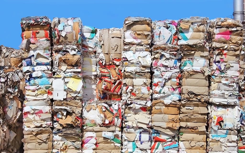 Recyclable cardboard boxes organized in a recycling facility, illustrating fiber lifespan and sustainability challenges.