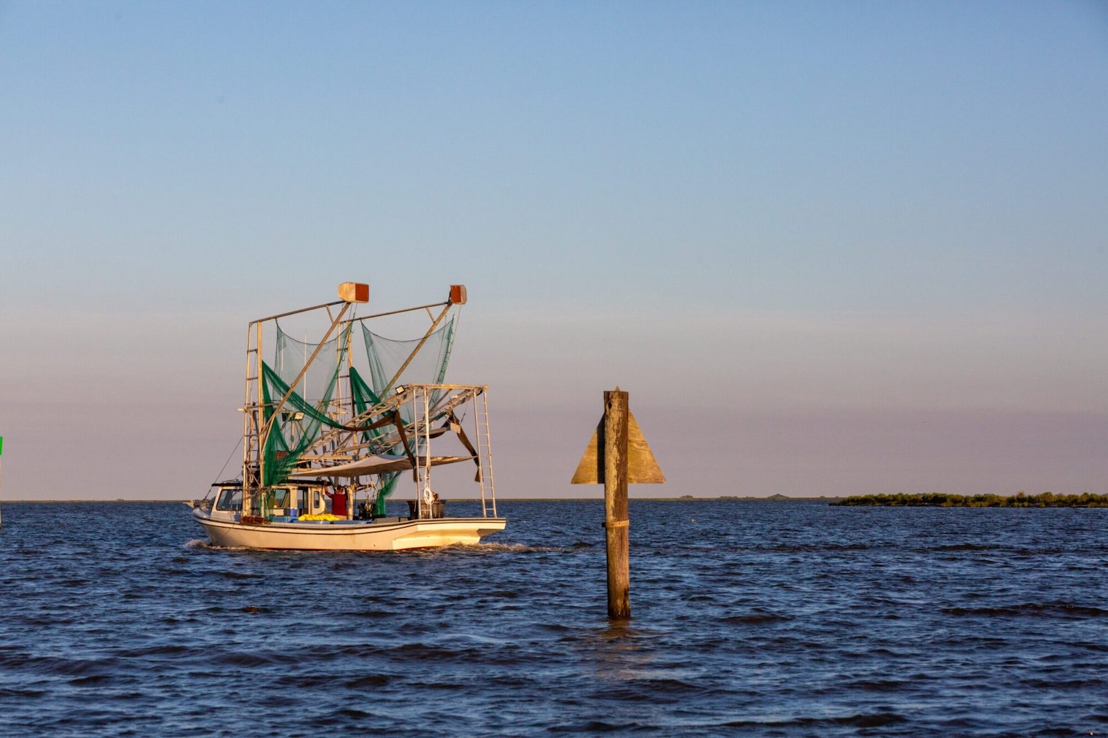 A fishing boat heads out on deep blue water