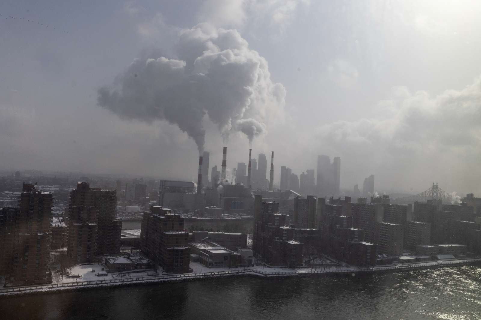 Steam rises from the smokestacks of the Ravenswood Generating Station, the largest power plant in New York City. The state has struggled to build out enough clean power to replace its natural gas power plants.