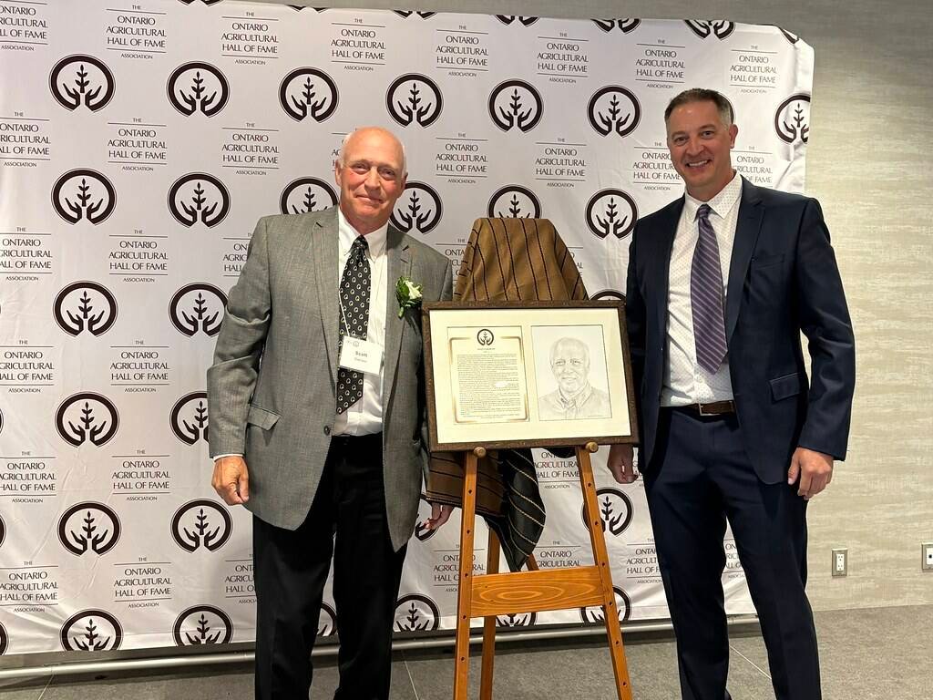 OAHF board member Alan Rickard assists inductee Scott Graham in unveiling his portrait. Photo: Ontario Agricultural Hall of Fame.