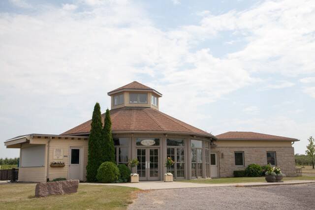The Wilmot Orchards boutique and event venue, a stone building topped with a peaked tower, set against a cloudy sky. Photo: Courtney Stevens