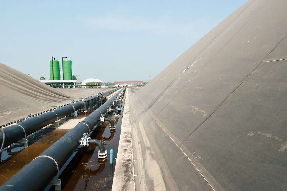 Covered anaerobic digestion tanks with associated pipework at a biogas production facility