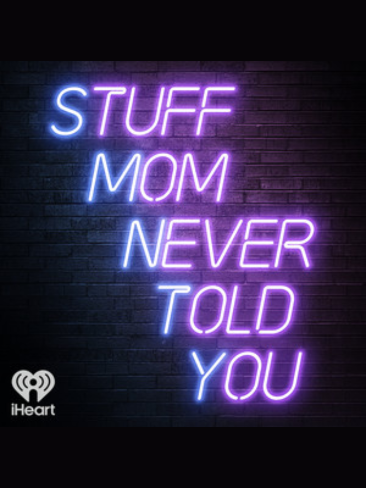 Neon-style text reads “STUFF MOM NEVER TOLD YOU” on a dark brick wall background, with the iHeart logo in the lower left corner.