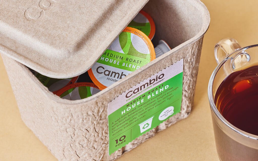 Cambio eco-friendly coffee pods in recyclable fiber-based packaging, promoting sustainability and carbon footprint reduction.