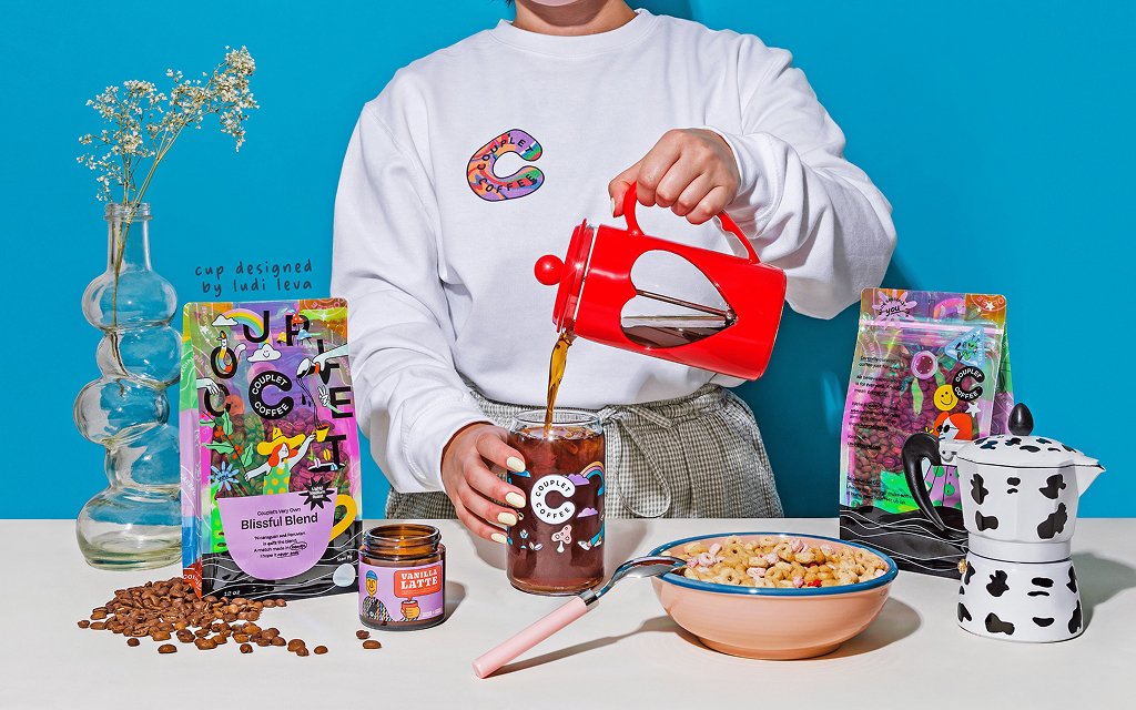 Couplet Coffee packaging featuring holographic full-coverage film with vibrant rainbow effect and playful coffee-inspired illustrations.