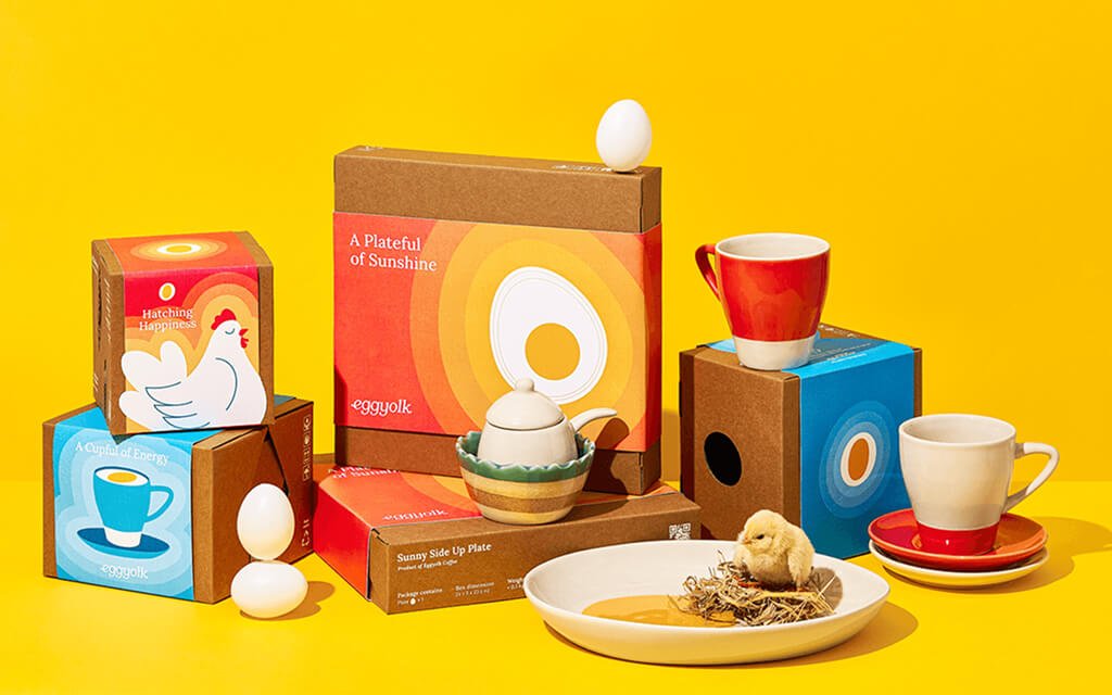 Eggyolk Coffee packaging featuring vibrant red, orange, and yellow colors with a sunny side up egg logo.