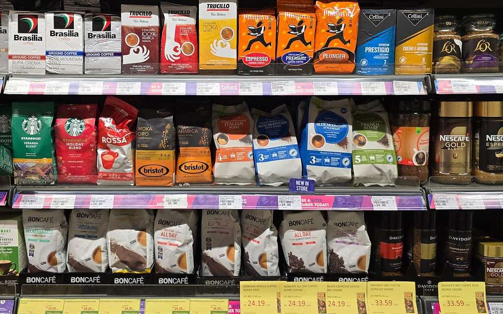 Colorful coffee packaging designs displayed on a retail shelf, showcasing various branding styles and formats.