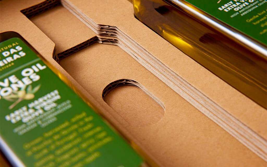 Olive Oil Jones bottle secured inside a shipping box with Zenpack's triangular corrugated inserts.