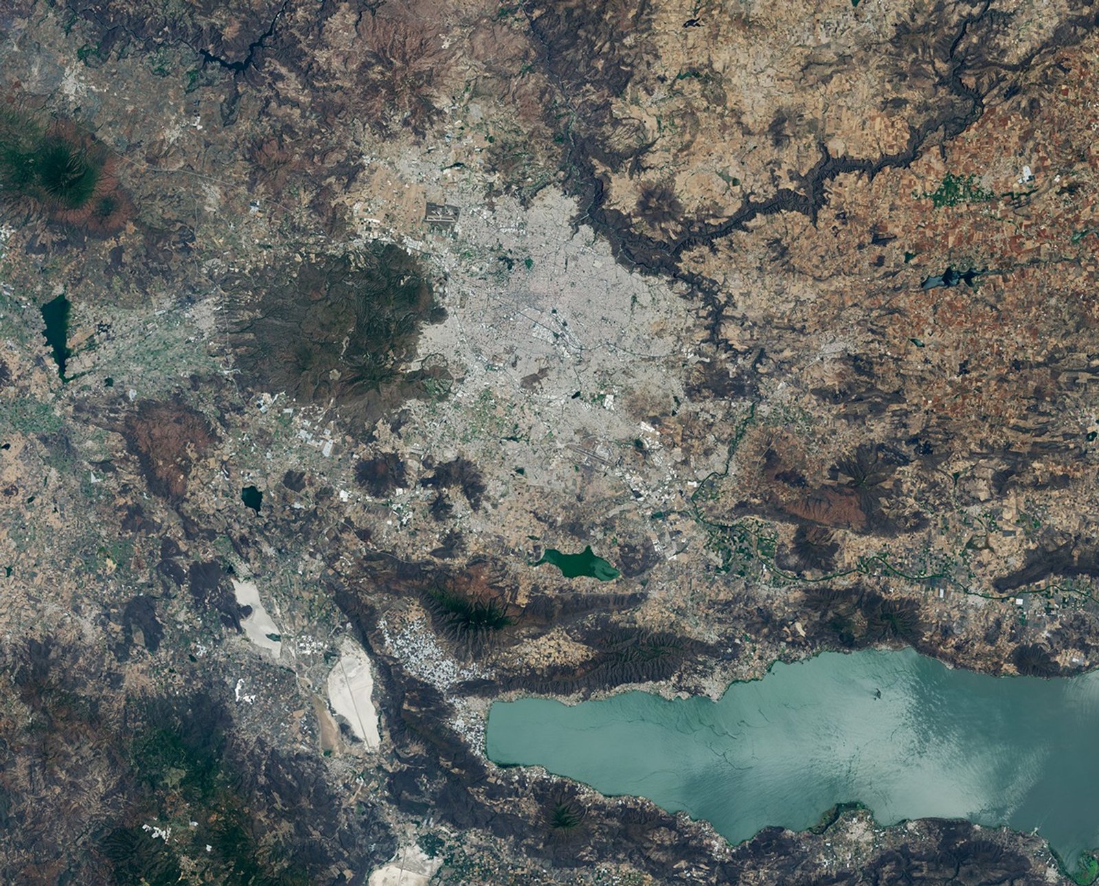 Images of Guadalajara in 1986 (left) and 2026 (right) shows the city expanding westward into an area that had been mostly farmland. Guadalajara Stadium appears as a small circular feature on the left side of the 2026 image.