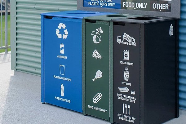 a recycling, compost, and trash bin sitting outside
