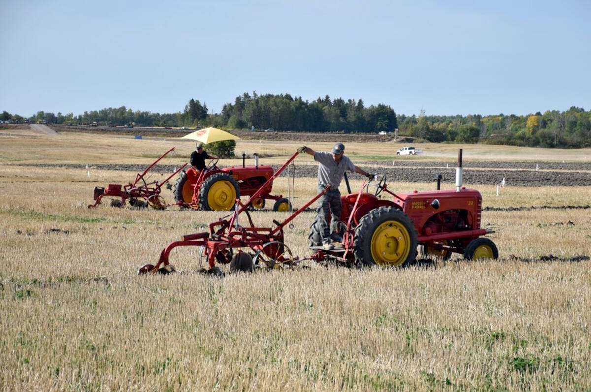 Two competitors plow with vintage red Massey-Harris tractors and trailing plows in a harvested stubble field. Photo: file