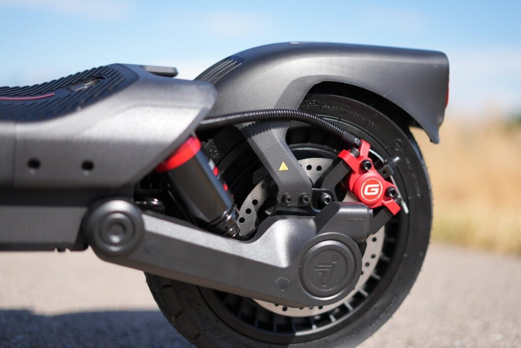 Rear disc brake, red caliper, and rear suspension linkage on the Segway MAX G3 Plus