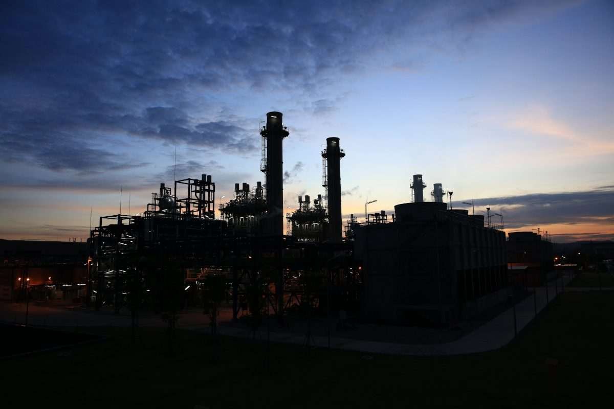 Silhouette of a large industrial plant or energy-intensive manufacturing facility at dusk