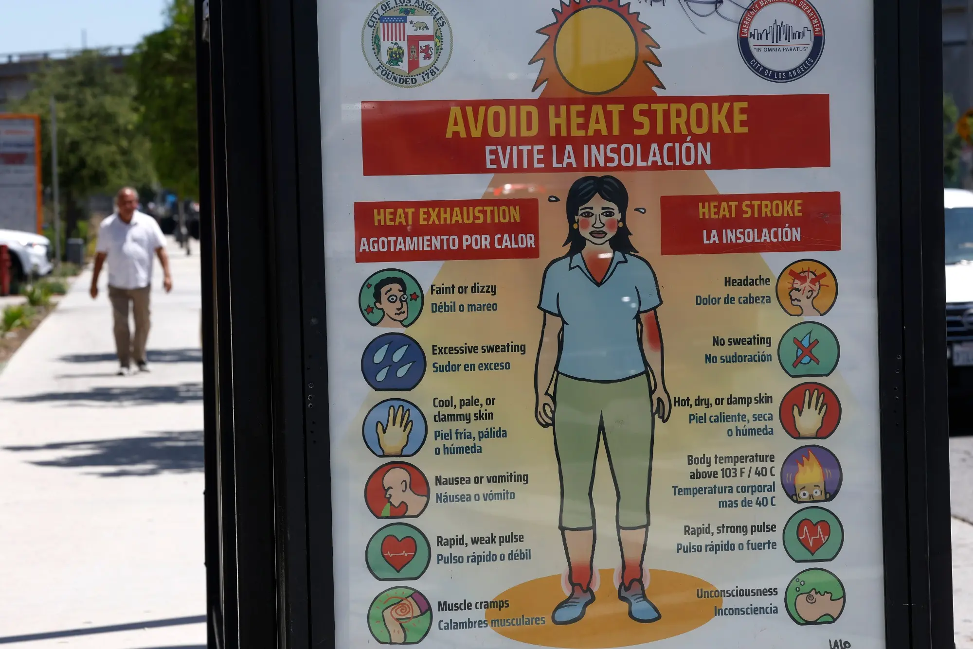 A bus stop with a poster reading Avoid Heat Stroke / Evite La Insolacion