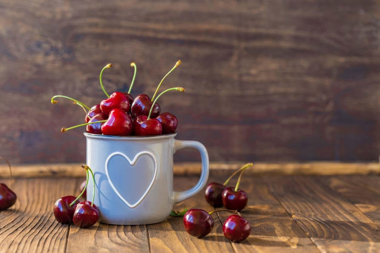 Sweet cherries in a mug with a heart on it