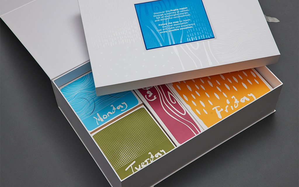 Seven-component rigid box ecosystem with custom four-sided sleeves by Zenpack, demonstrating premium packaging engineering for Puglia Regional Tourism Board