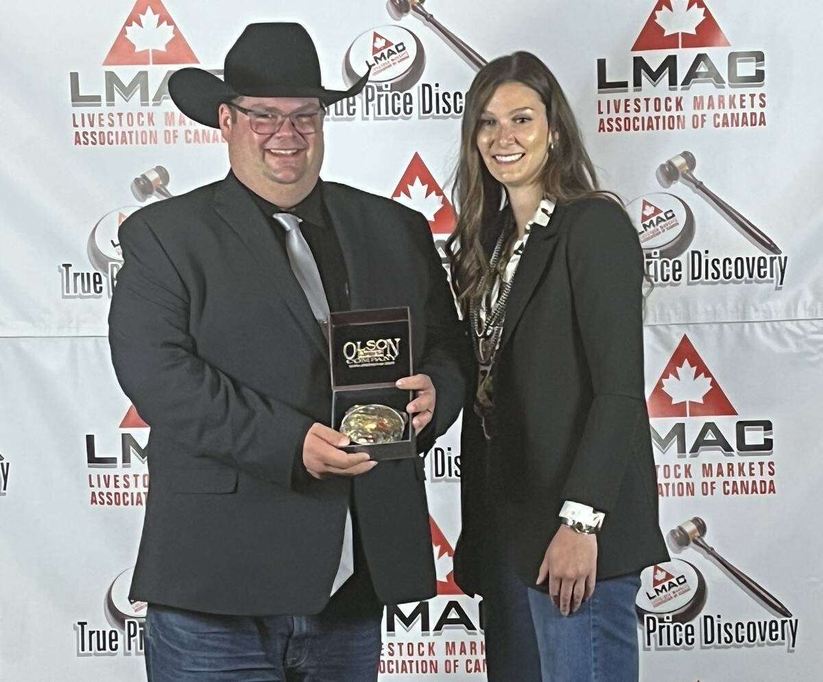 Dave Jacob receives his championship buckle from Shayla Chappell of the Canadian Shorthorn Association, after winning the 27th annual Canadian Livestock Auctioneer Championship in Maple Creek, Sask. Photo: Greg Price