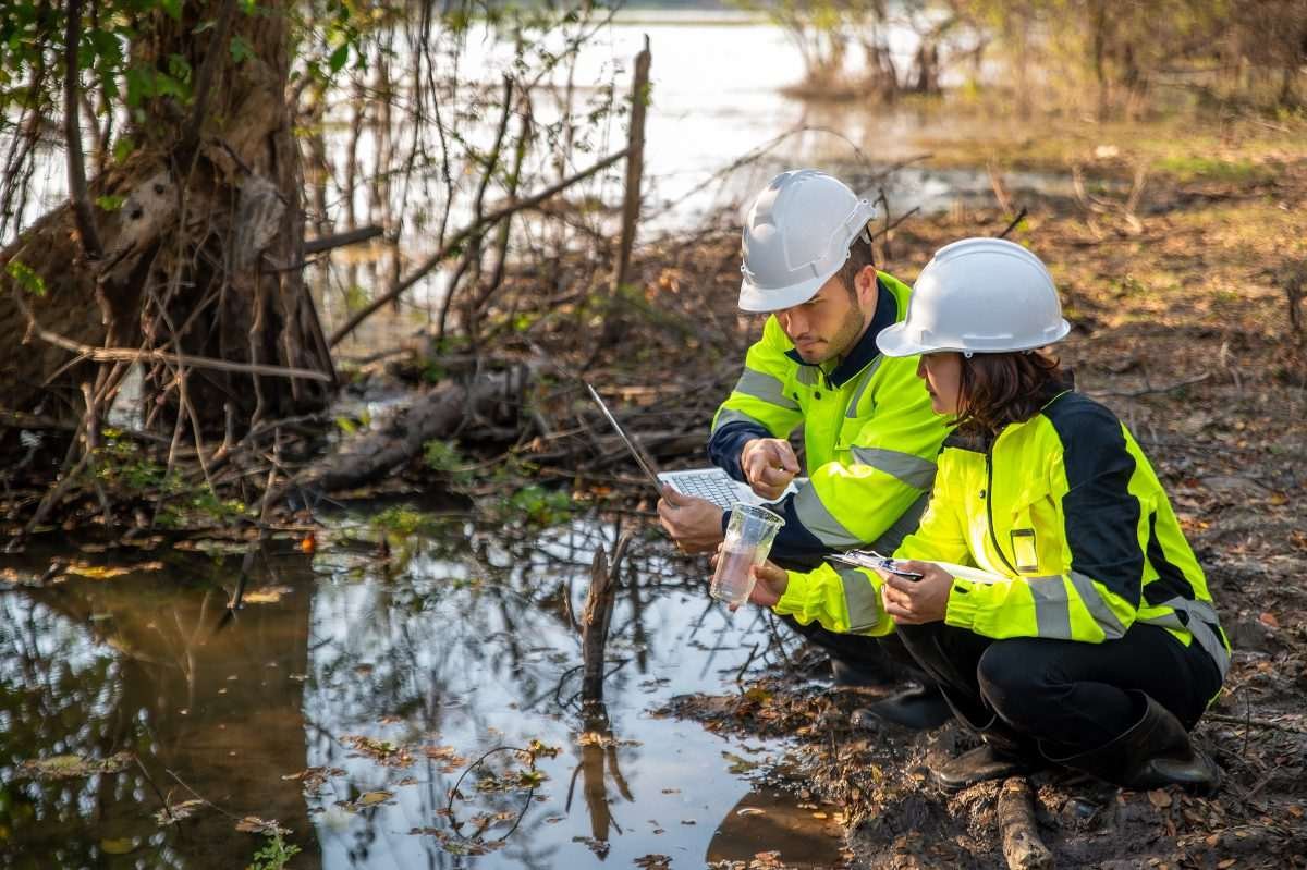 Engineers on river bank taking water samples