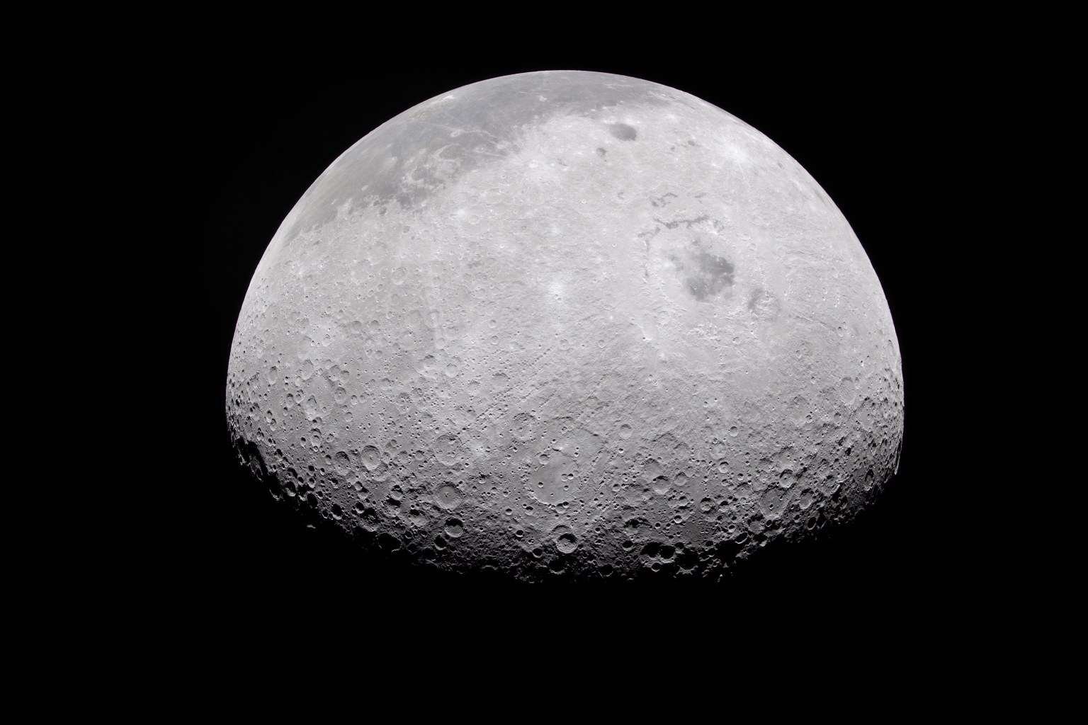 The Moon's rugged surface is on display in this image. Most of the Moon is visible, with the bottom of the sphere disappearing into the darkness. This line between light and dark is called the terminator. The terminator is lined with many craters.