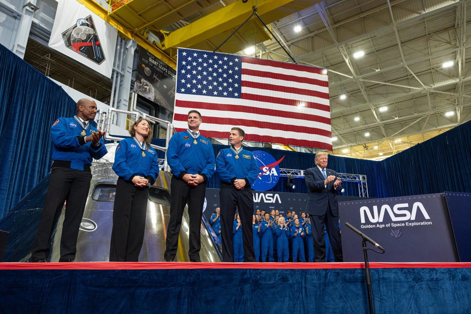 The four members of the Artemis II mission stand on stage after receiving the Congressional Space Medal of Honor. To their right is President Trump.