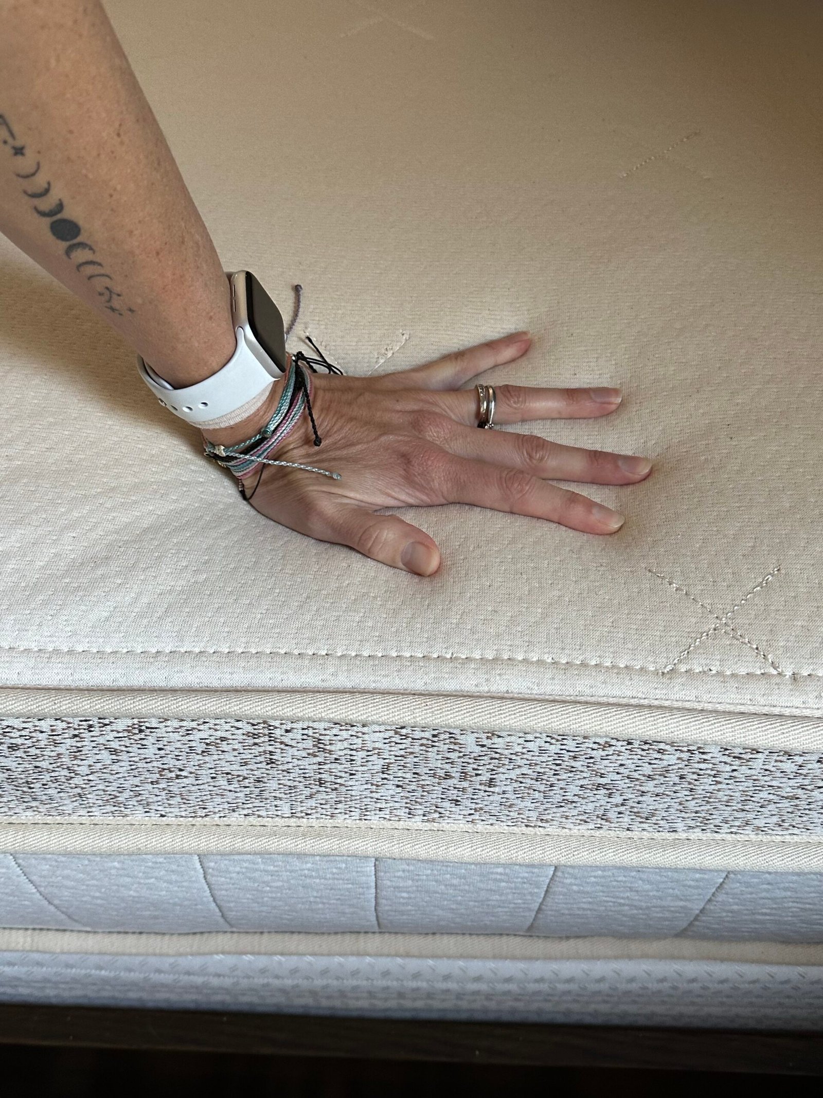 Hand pressing down on a Birch mattress. 