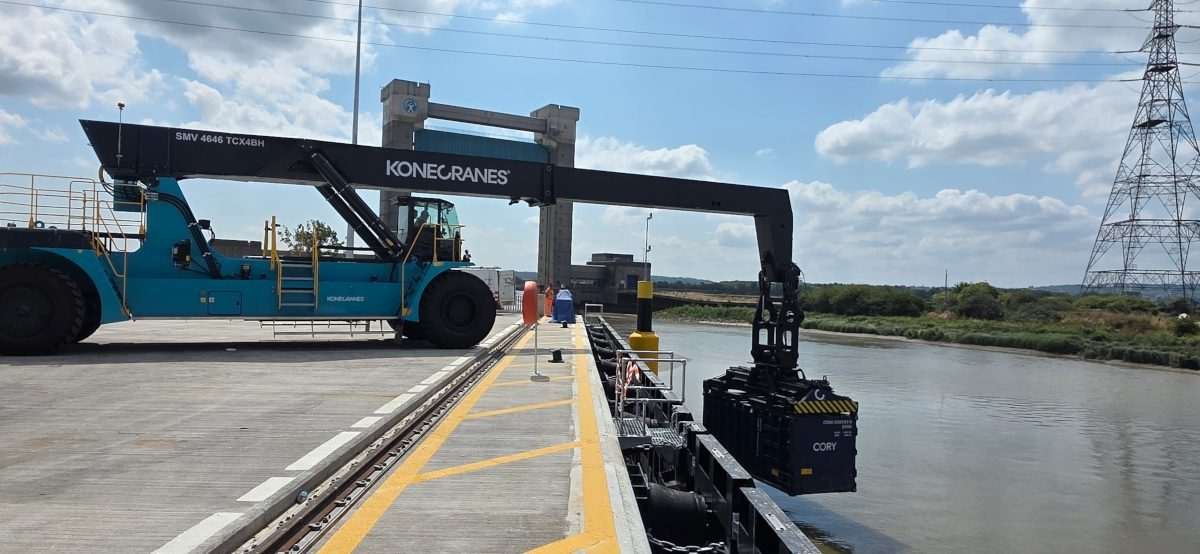 Konecranes reach stacker lifting a waste container from a barge at a recycling facility in Barking, London