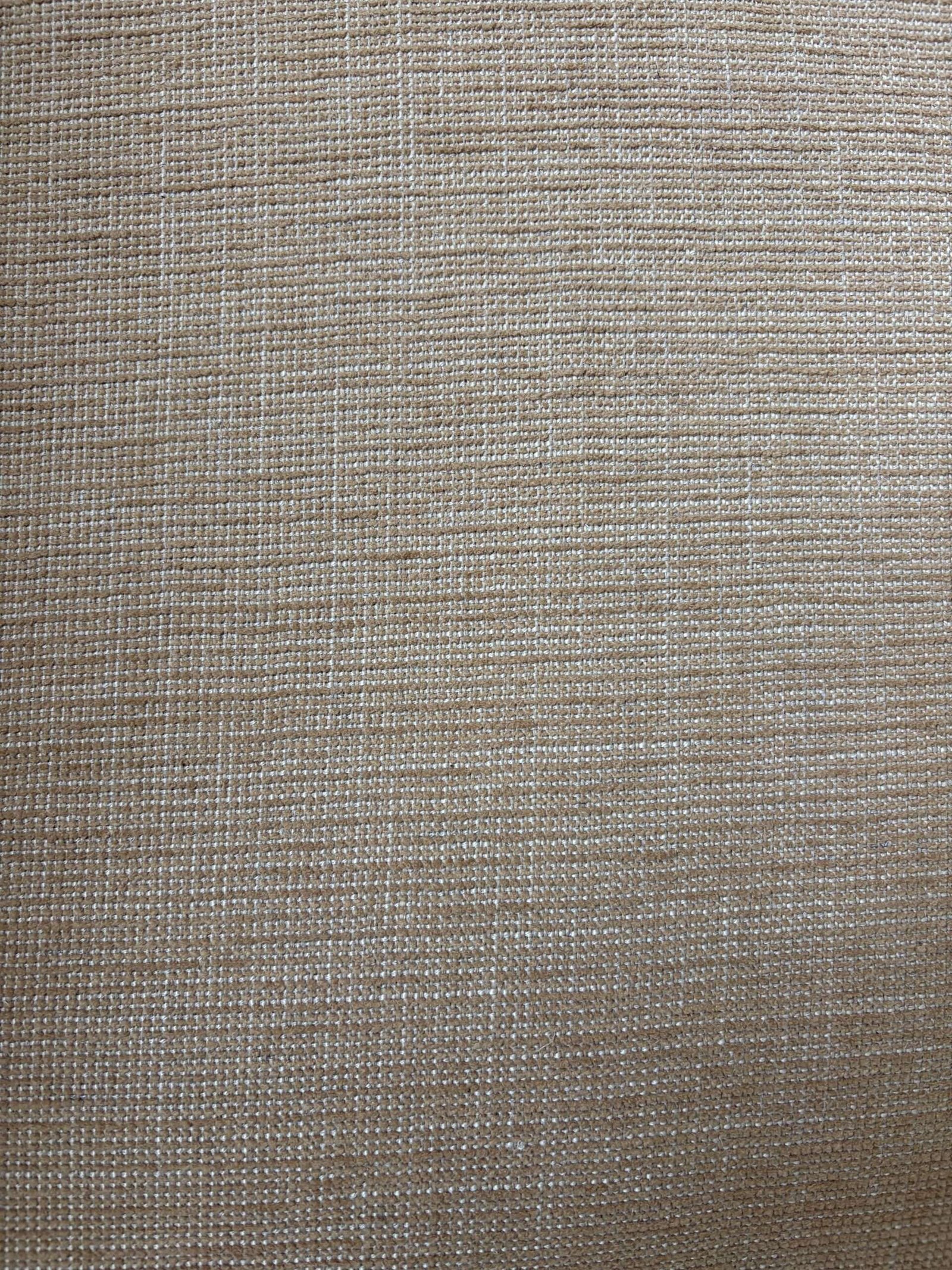 Close-up view of beige woven fabric with a visible textured pattern of intersecting threads.