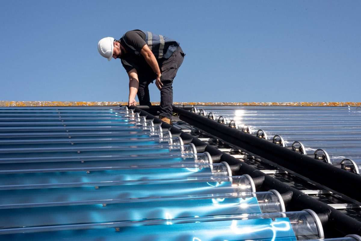 Engineer working on an array of Naked Energy VirtuHOT evacuated-tube solar thermal collectors at the University of Westminster.