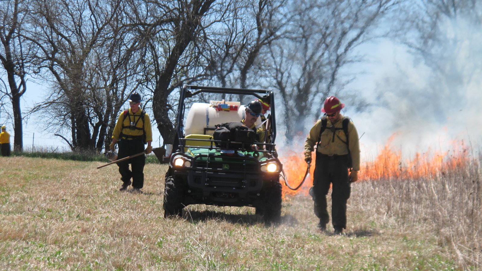 Crews walk along the fire line during a controlled burn at the Homestead National Monument in Beatrice, Neb., on Friday, April 22, 2016.