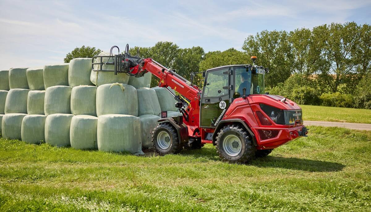 A Weidemann 2060T wheel loader with telescoping ability lifts bales in a field. It’s among three other wheel loaders the German company recently introduced to the Canadian market.