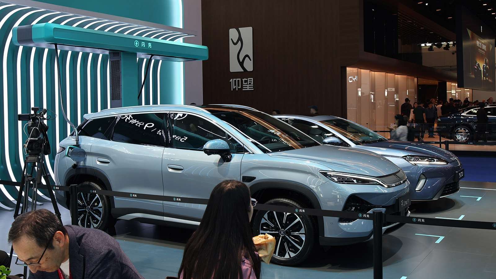BYD vehicles displayed beside a turquoise flash-charging unit at the Beijing Auto Show in April 2026.