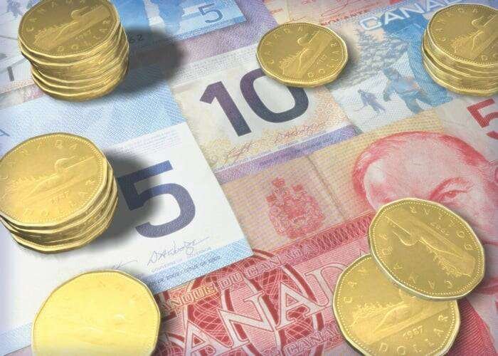 Canadian five and ten dollar bills with stacks of loonies. Photo: file