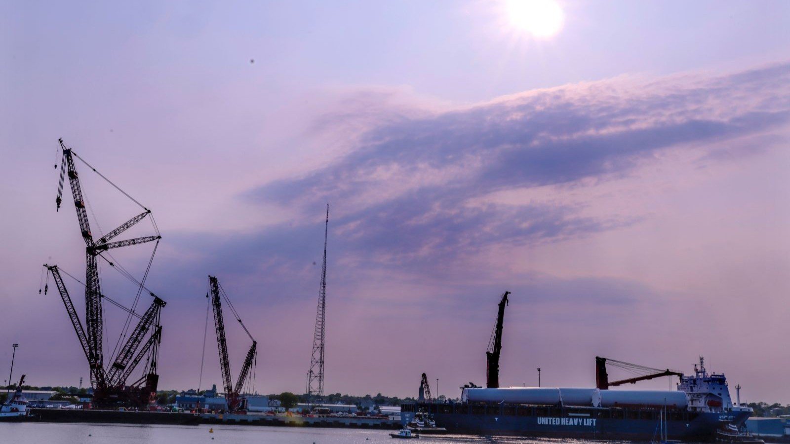 A barge carrying pieces of an offshore wind farm preparing to leave harbor
