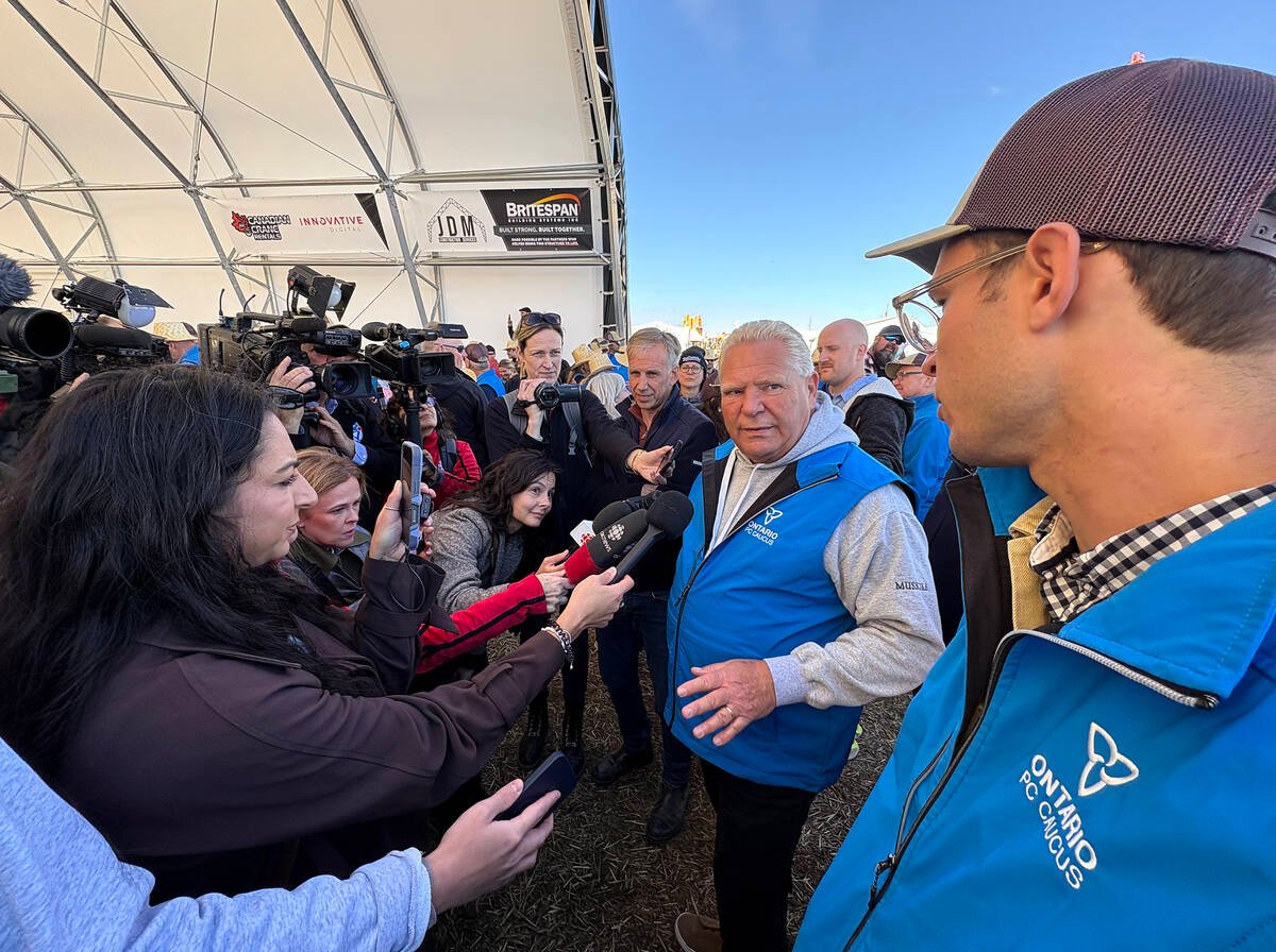 Premier Doug Ford and newly appointed agricultural minister Sam Oosterhoff, right, face a sea of media microphones and cameras at the International Plowing Match and Rural Expo opening ceremony in Walkerton, Ont. Photo: Diana Martin