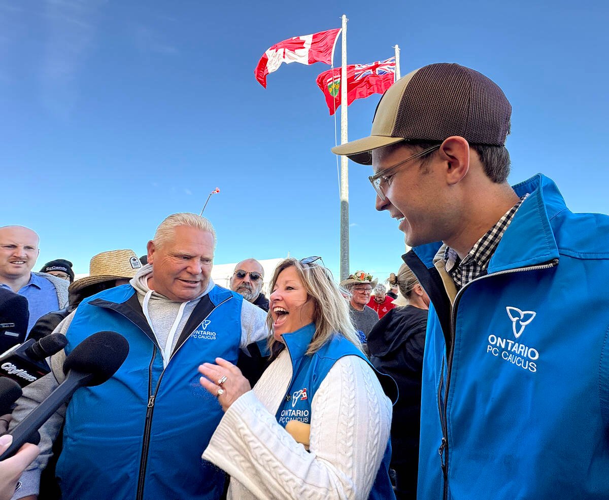 The Canada and Ontario flags flap in the background as Premier Doug Ford, left, and ministers Lisa Thompson, centre, and Sam Oosterhoff address the media at the International Plowing Match and Rural Expo in Walkerton, Ont. Photo: Diana Martin