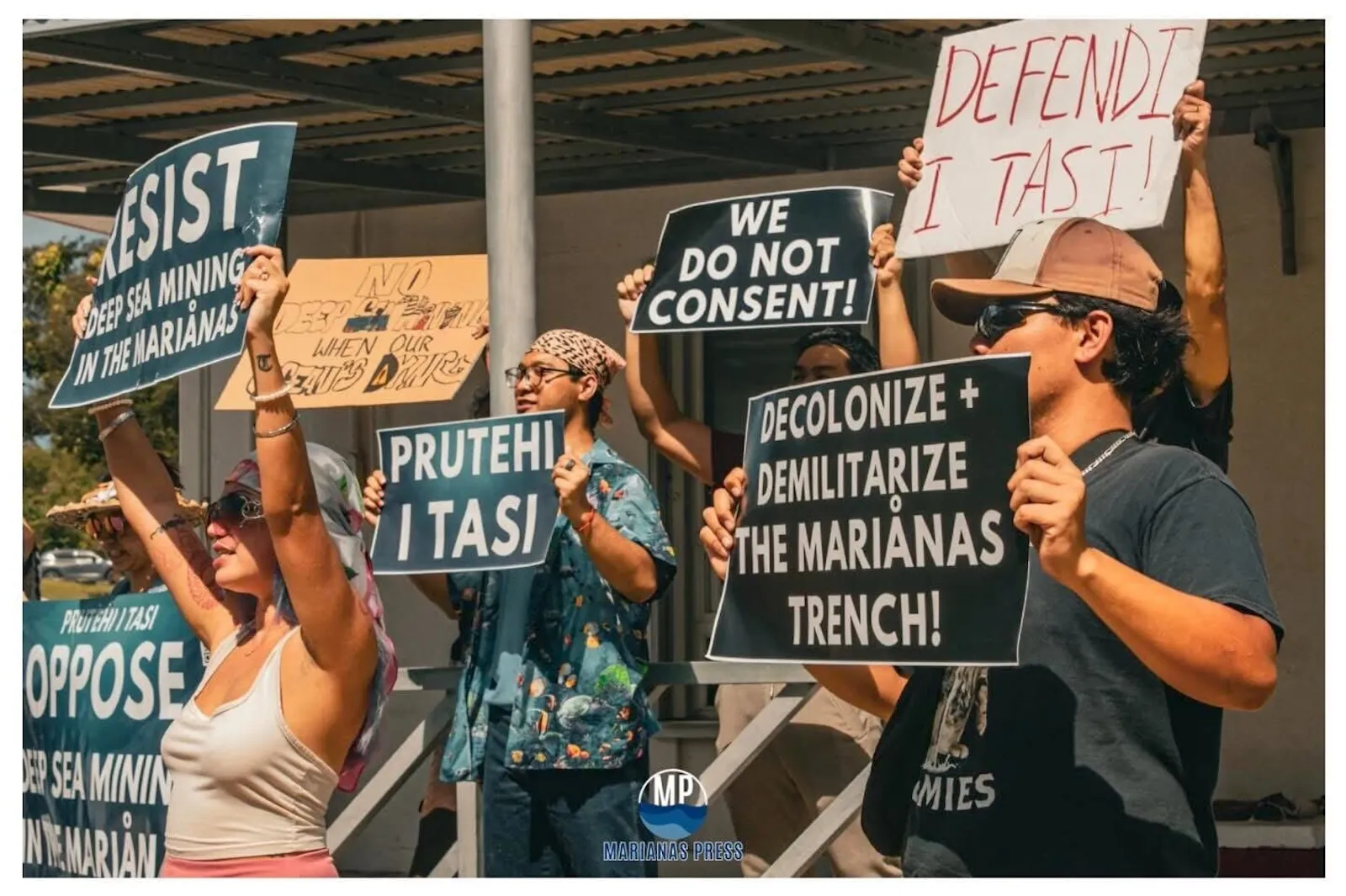 Protesters holding up signs against seabed mining