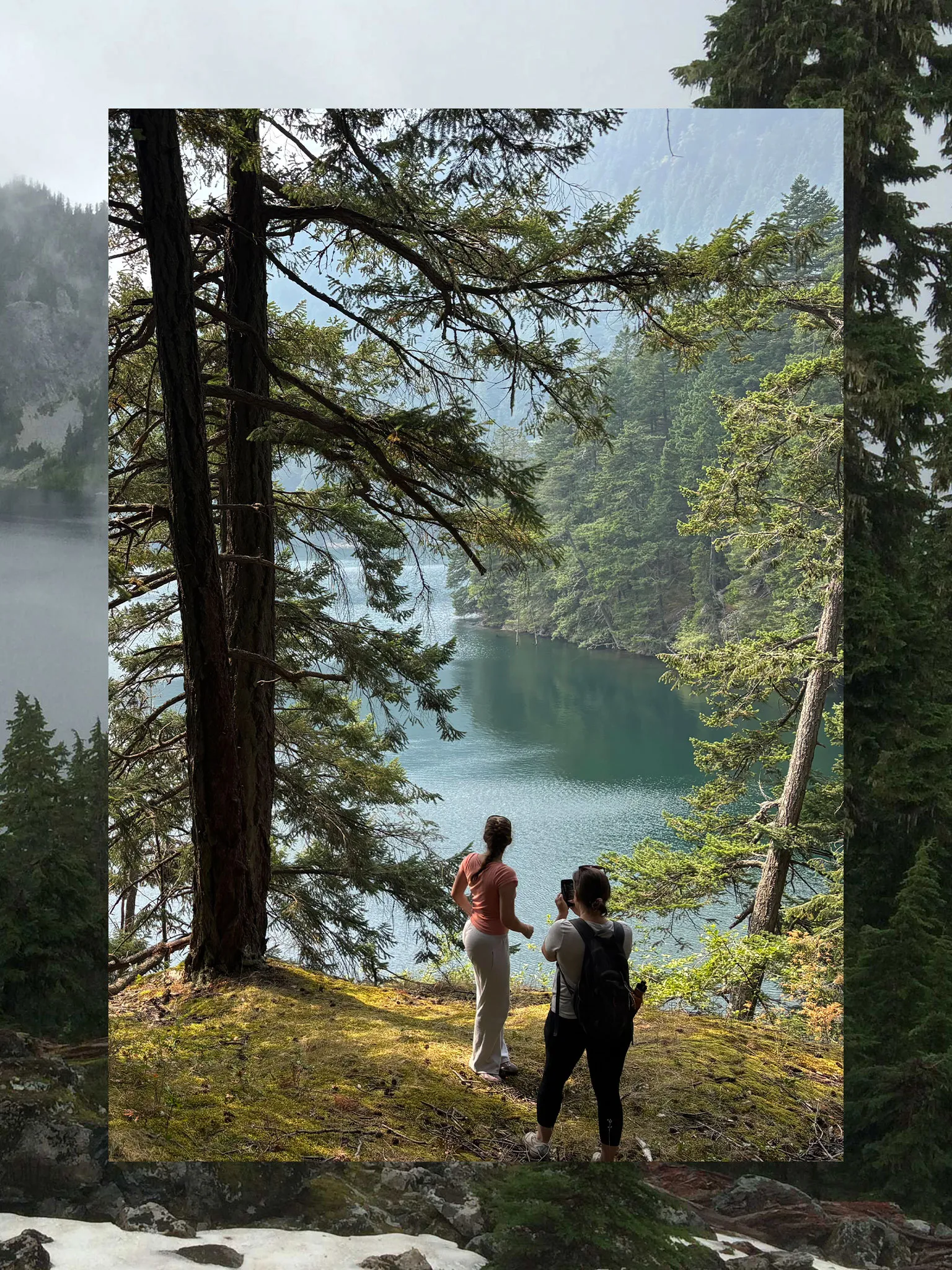 A collage consisting of two vertical photos, the outside functioning a border and the inside fully visible. The outside photo is a misty trail with trees and mountains. The inner photo is two people on a hike near a wooded lake.