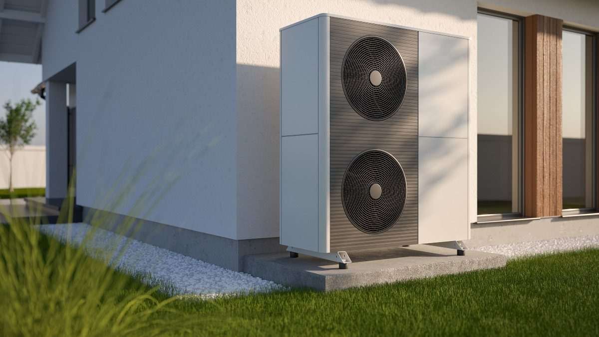 Outdoor air-to-water heat pump unit installed beside a modern house