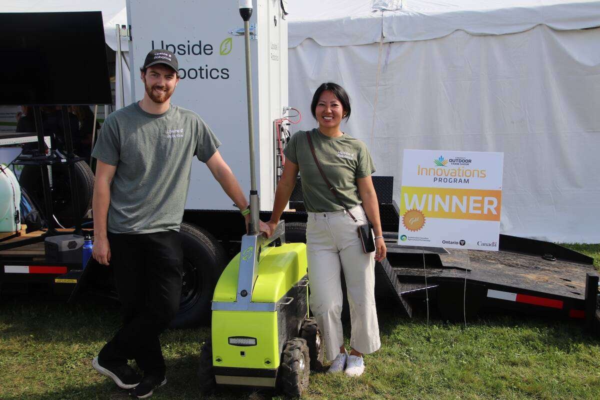 Sam Dugan, left, and Jana Tian with Upside Robotics’ Innovation Awards gold sign. The Waterloo-based company plans to expand next year and add more partner farmers. Photo: Jonah Grignon