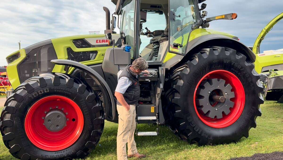 Frans Reijmers demonstrating where the toolbox is located under the stairwell on the Claas Axion 9 tractor. Photo: Greg Berg