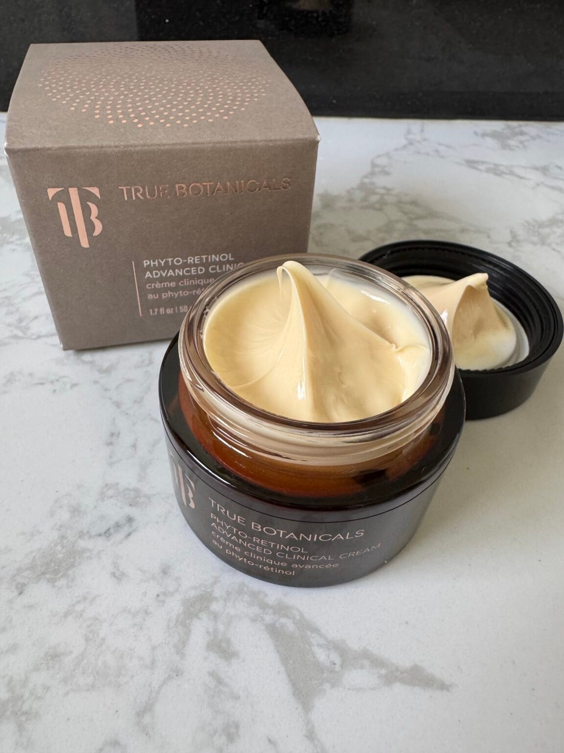 True Botanicals Phyto-Retinol Advanced Clinical Cream in an open jar with its box and lid nearby.