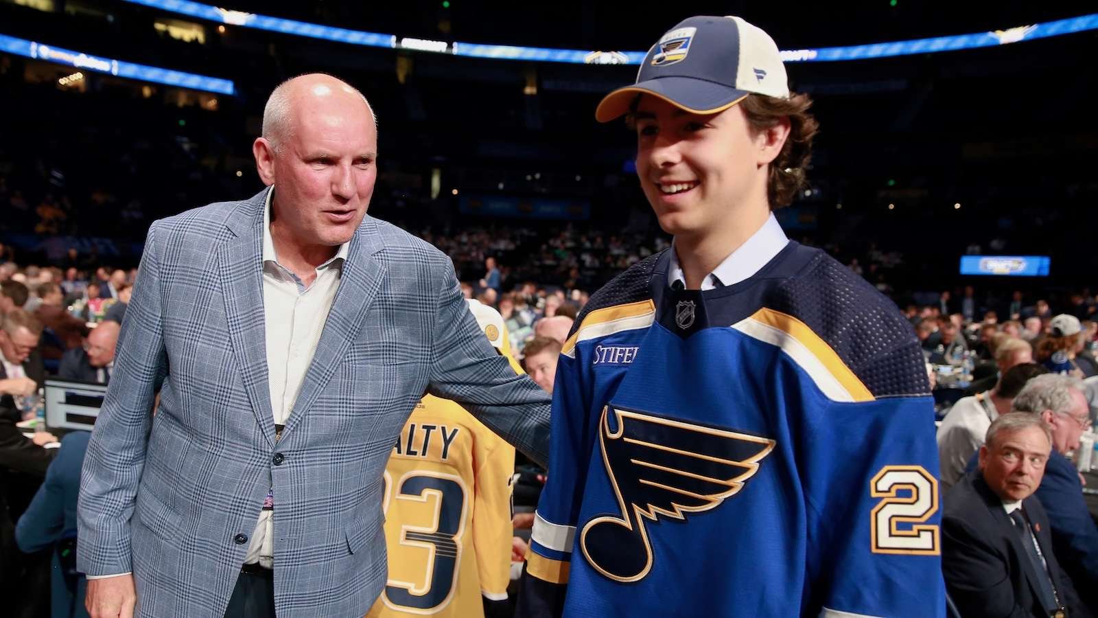 Matthew Mayich, wearing a St. Louis Blues jersey, smiles after being drafted by the team.