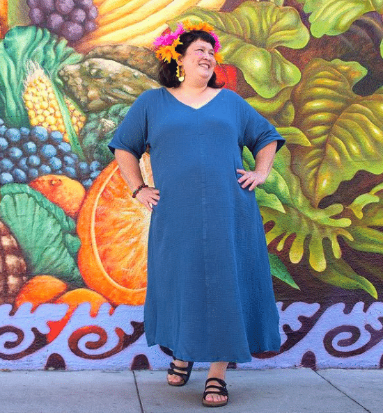 A model wearing a maxi denim dress with quarter-length sleeves and a v-neckline.