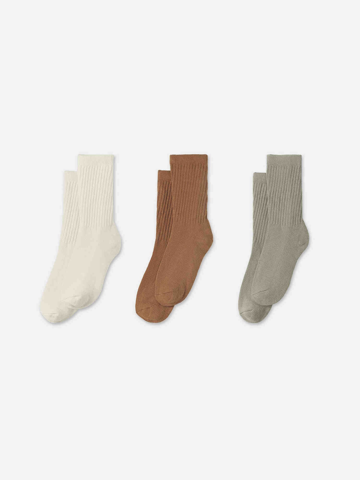 Three pairs of ribbed crew socks in off-white, brown, and grey.