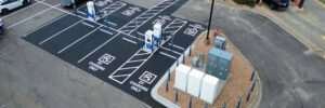 Aerial view of an EVgo charging hub with marked charging bays, bollards and electrical equipment.