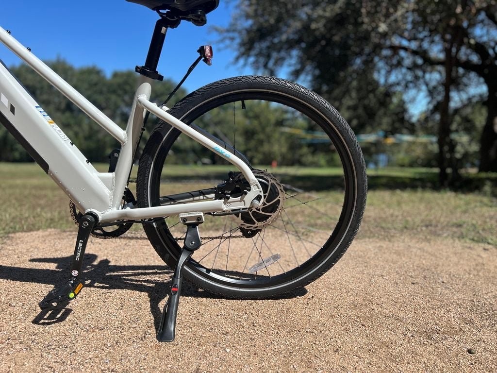 Lectric XPress Lite rear wheel and folding steel kickstand on the mid-step frame