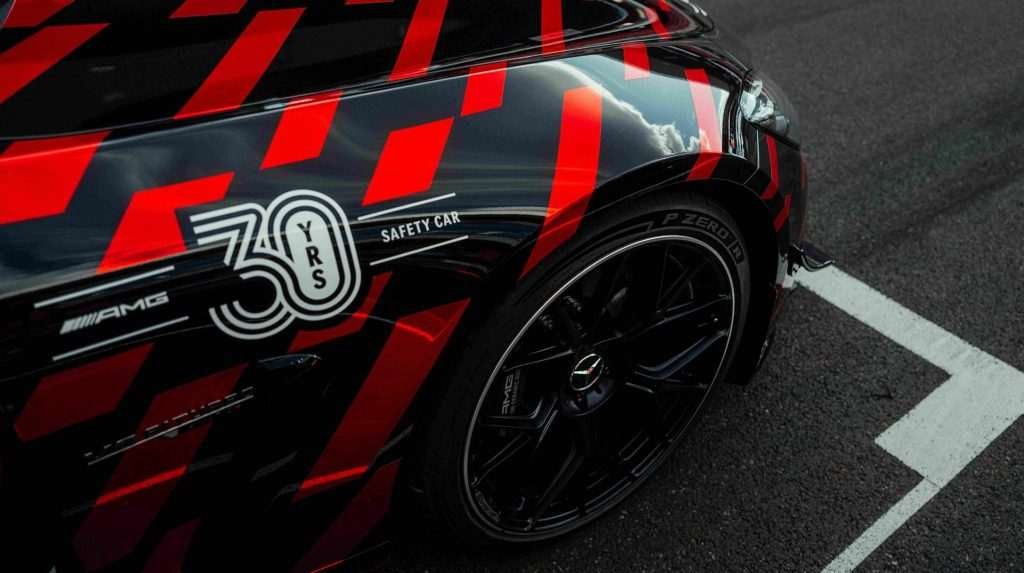 A F1 safety car with black and red livery and Pirelli tires.