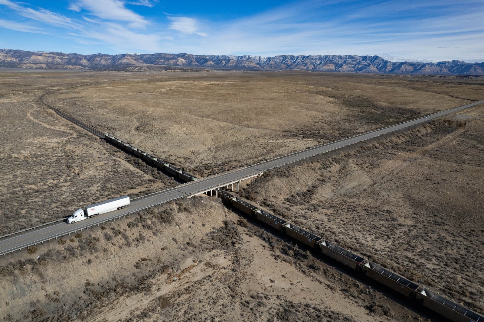 Empty coal cars sit idle against a barren landscape in Carbon County, Utah.