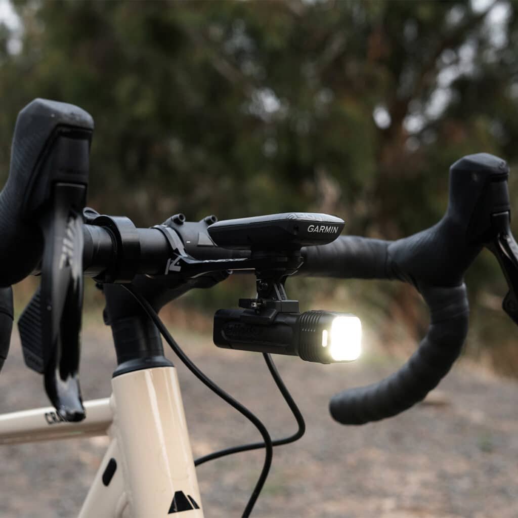 Knog Blinder 1300 headlight mounted under a bike computer on a handlebar